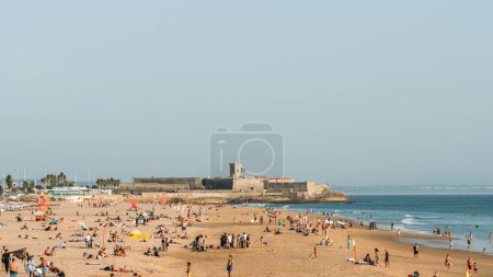 Photo for The people on the crowded beach Carcavelos in Lisbon, Portugal on a sunny autumn afternoon - Royalty Free Image