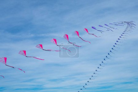 Téléchargez les photos : Une rangée de cerfs-volants colorés dans le ciel bleu - en image libre de droit