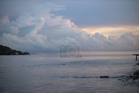 Téléchargez les photos : Le beau paysage d'un bateau dans la mer avec un ciel nuageux dramatique en arrière-plan au coucher du soleil - en image libre de droit