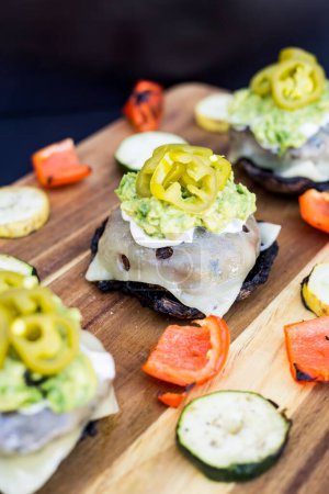 Téléchargez les photos : Un plan vertical de burgers avec des jalapenos marinés et des légumes grillés sur une table en bois - en image libre de droit