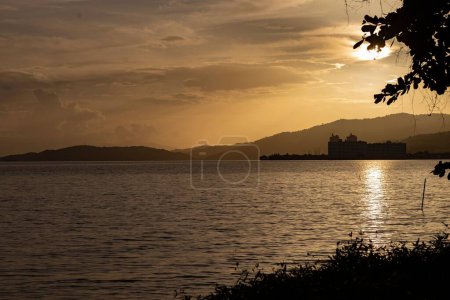 Téléchargez les photos : Un beau coucher de soleil sur le rivage avec un ciel nuageux en arrière-plan - en image libre de droit