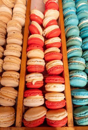 Photo for A vertical high-angle view of trays of colorful macarons displayed on a wooden stand - Royalty Free Image