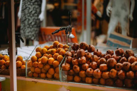 Téléchargez les photos : Une concentration sélective de grenades et de mandarines dans des boîtes contre une machine à jus - en image libre de droit