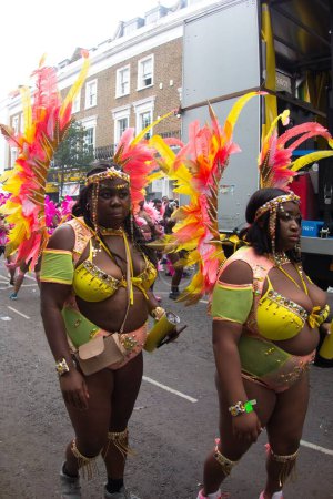 Foto de Un grupo de personas que asisten al Carnaval de Notting Hill 2022 en el Reino Unido con trajes coloridos - Imagen libre de derechos