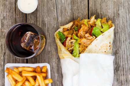 Téléchargez les photos : Un gros plan de shawarma avec des frites et un verre de soda - en image libre de droit