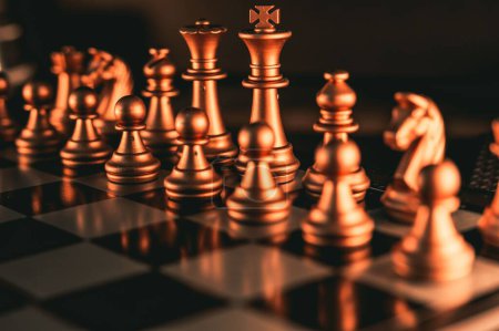 Foto de Un primer plano de piezas de ajedrez de oro en un tablero de ajedrez - Imagen libre de derechos