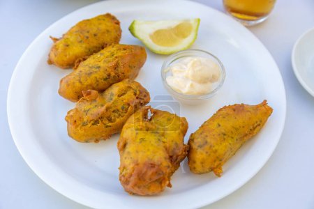 Foto de Un primer plano de nuggets de pollo con una salsa en un plato - Imagen libre de derechos