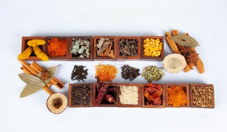 Téléchargez les photos : Une vue de dessus des épices indiennes savoureuses et épicées servies dans des boîtes en bois avec mélange de thé masala - en image libre de droit