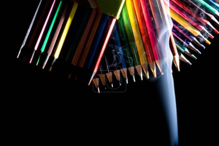 Photo for Sharp colorful pencils with smoke on black background - Royalty Free Image