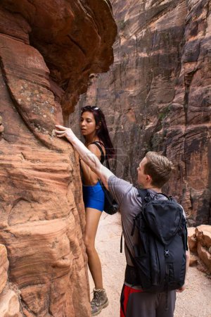 Foto de Un plano vertical de un hombre enseñando a una joven a escalar rocas en un parque - Imagen libre de derechos