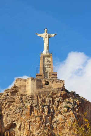 Photo for The statue of Jesus and the castle of Castillo de Monteagudo in Spain against the blue sky - Royalty Free Image