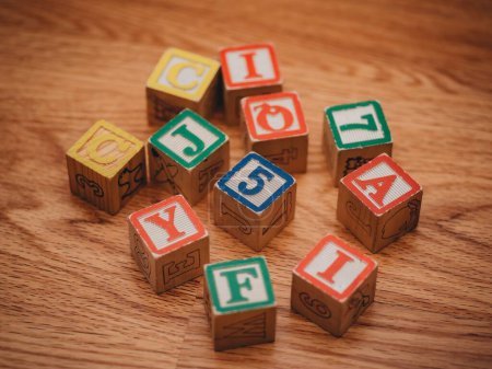 Téléchargez les photos : Un gros plan de blocs d'alphabet en bois coloré sur le plancher de bois franc - en image libre de droit