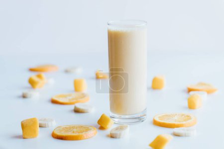 Foto de Un primer plano de un vaso de batido con naranjas sobre un fondo blanco - Imagen libre de derechos