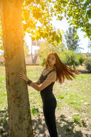 Foto de Una hermosa hembra en un parque durante el entrenamiento de fitness en el soleado día de verano - Imagen libre de derechos