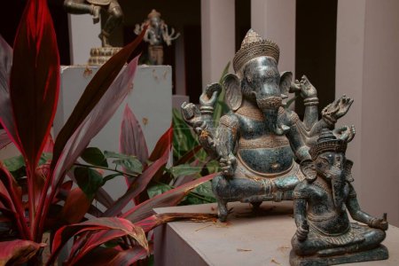 Téléchargez les photos : Une vue panoramique d'une statue en laiton du dieu hindou Ganesha au milieu d'un jardin tropical - en image libre de droit