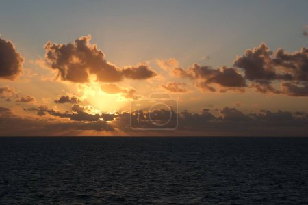 Téléchargez les photos : Majestueux lever de soleil lumineux sur l'océan avec des vagues de lumière à la surface - en image libre de droit