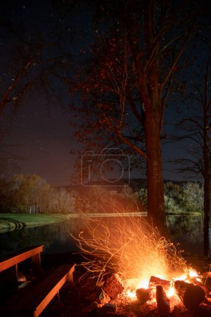 Foto de Una vertical de una chimenea junto al lago por la noche - Imagen libre de derechos