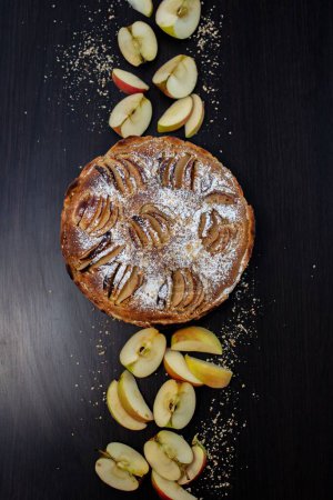 Photo for A closeup of a delicious apple pie on a table with sliced apples - Royalty Free Image
