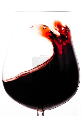 Photo for A vertical closeup shot of red wine in the transparent glass against the white background - Royalty Free Image