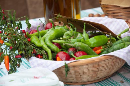 Photo for A wooden basket with green and red chili peppers in a market - Royalty Free Image