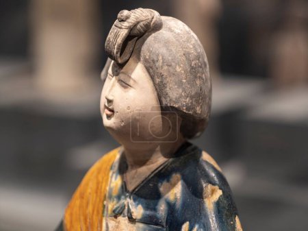 Téléchargez les photos : Un gros plan de la figurine en argile d'une femme est-asiatique en costume national sur un fond flou - en image libre de droit