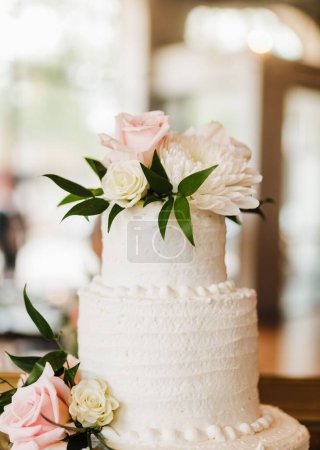 Téléchargez les photos : Le beau gâteau de mariage blanc décoré de fleurs préparées pour la cérémonie de mariage - en image libre de droit