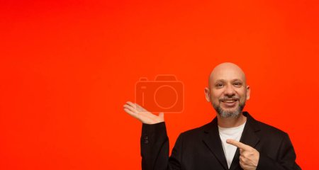 Foto de Retrato de un hombre de negocios con estilo haciendo gestos de mano. Mirando a la cámara. Aislado sobre fondo naranja. - Imagen libre de derechos