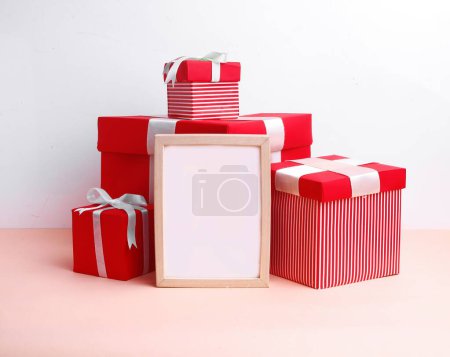 Foto de Linda configuración de Navidad con cajas de regalo rojas y marco de madera en blanco en el centro - Imagen libre de derechos