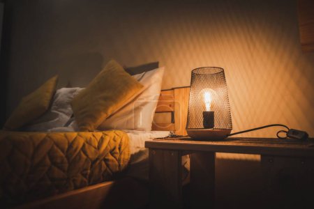 Téléchargez les photos : Une lampe sur une table de chevet dans une chambre - en image libre de droit