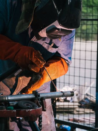 Téléchargez les photos : Un homme travaillant sur le soudage du fer dans un atelier - en image libre de droit