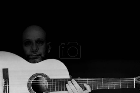 Téléchargez les photos : Un plan en niveaux de gris d'un guitariste masculin charismatique caucasien - en image libre de droit
