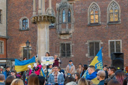 Téléchargez les photos : Personnes organisant des manifestations anti-russes contre la guerre hissant des drapeaux ukrainiens, tir vertical - en image libre de droit