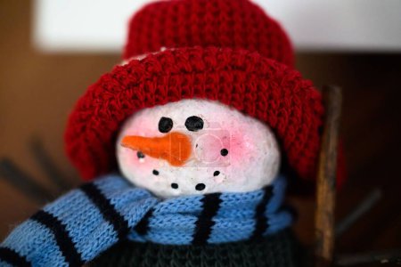 Foto de Un muñeco de nieve de punto con un sombrero rojo y una bufanda - Imagen libre de derechos