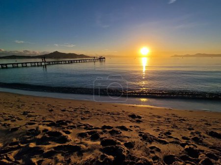 Téléchargez les photos : Une vue aérienne de la mer avec quai au coucher du soleil - en image libre de droit
