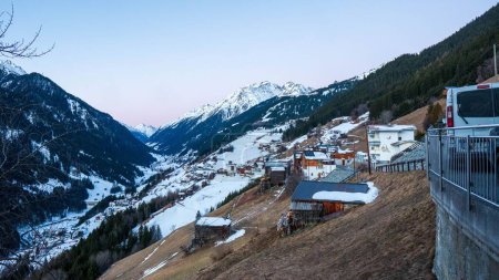 Téléchargez les photos : La vue forme une terrasse donnant sur les bâtiments face aux montagnes rocheuses enneigées de Kappl, Autriche - en image libre de droit