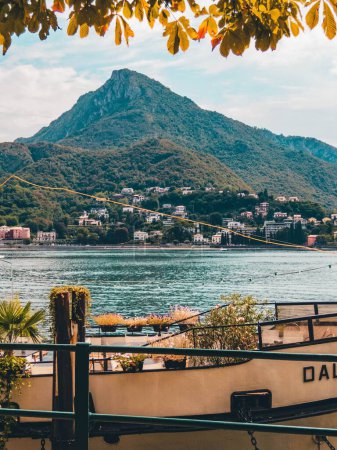 Photo for A vertical shot of the calm Como Lake in Lecco city Italy with big mountains in the background - Royalty Free Image