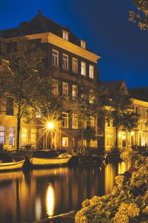 Téléchargez les photos : Un plan vertical de la rivière avec les bâtiments en arrière-plan, Leyde, Pays-Bas - en image libre de droit
