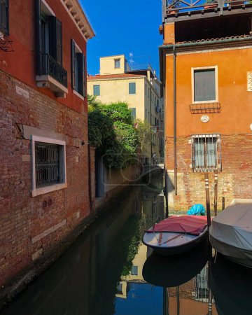 Foto de Un disparo vertical de canoas frente a los edificios en un día soleado en Venecia, Italia - Imagen libre de derechos