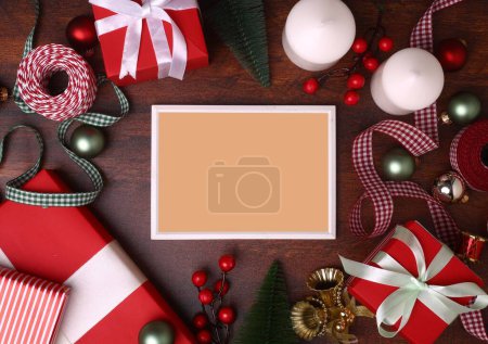 Téléchargez les photos : Un cadre vide sur une surface en bois entourée par les décorations de Noël - en image libre de droit