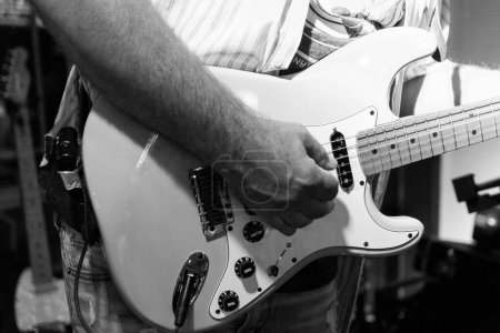 Photo for A grayscale of a man playing a electric guitar in a concert - Royalty Free Image