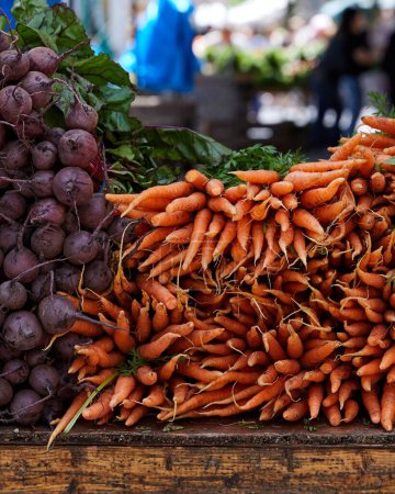 Foto de Un primer plano de verduras para la venta en un mercado de agricultores al aire libre zanahorias, rábano, nabo, remolacha - Imagen libre de derechos