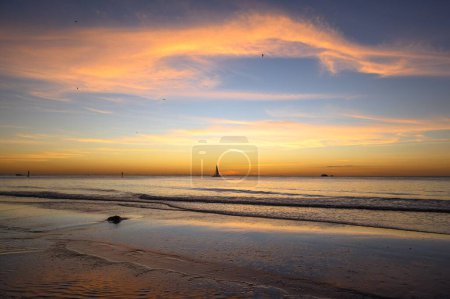 Téléchargez les photos : Un ciel de coucher de soleil pittoresque sur la mer avec des bateaux - en image libre de droit