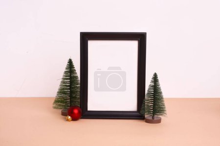 Foto de Un primer plano de una composición decorativa de Navidad con un marco y árboles de Navidad sobre un fondo blanco - Imagen libre de derechos