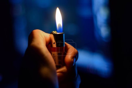 Foto de Un primer plano de una persona encendiendo un encendedor en la oscuridad - Imagen libre de derechos