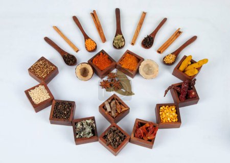 Photo for A top view of flavorful and spicy Indian spices served in wooden boxes and spoons with masala tea mix - Royalty Free Image