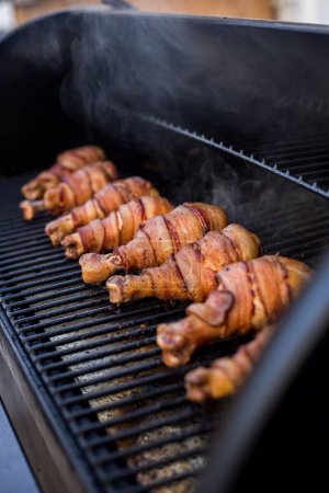 Photo for A grill with chicken legs wrapped in bacon - Royalty Free Image