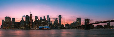 Photo for A panoramic view of the Brooklyn Bridge with the skyline of New York in the background at sunset - Royalty Free Image