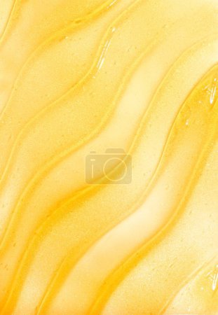 Photo for A vertical shot of a gold skincare slushed on a white background - Royalty Free Image