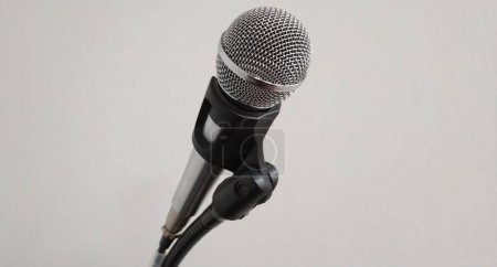 Photo for A microphone on a stand against a white wall background. - Royalty Free Image