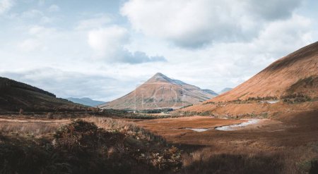 Foto de Una hermosa vista de las montañas con pendientes marrones bajo un cielo nublado en el campo de Escocia - Imagen libre de derechos